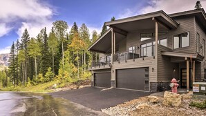 A modern two-story house with a garage, a balcony, and a fire hydrant in front.