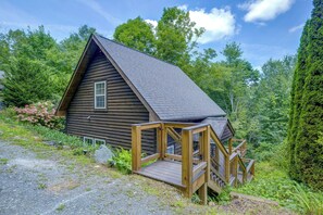 A cabin with a wooden deck and a staircase leading to the entrance. - Cozy Boone Cabin w/ Deck: Close to Downtown! (Boone)