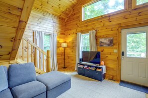 A wooden interior with a sofa, a television, and a door. - Cozy Boone Cabin w/ Deck: Close to Downtown! (Boone)