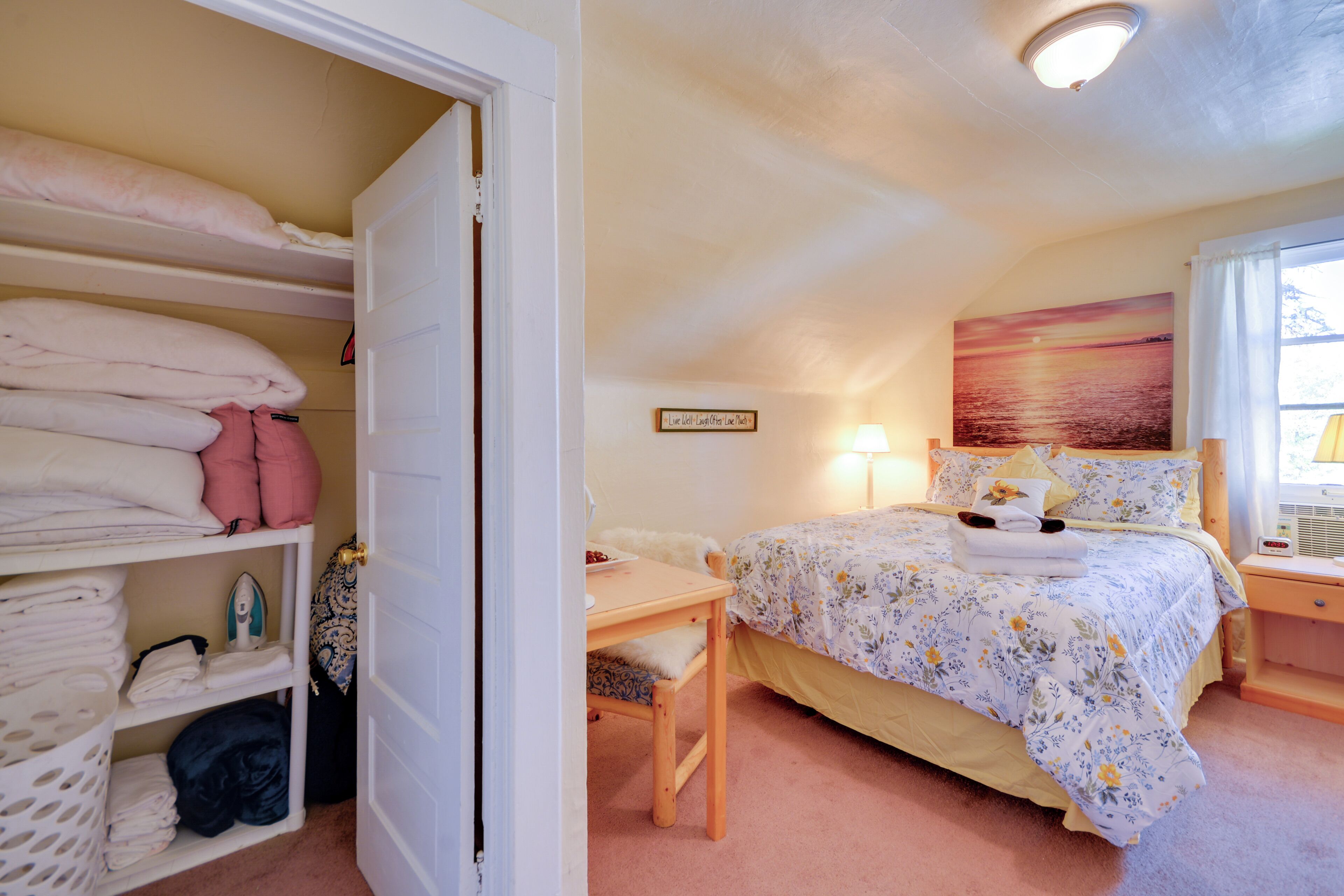 A bedroom with a bed, a desk, and a wardrobe.
