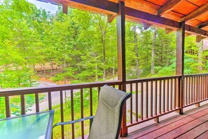 A wooden deck with a metal railing overlooking a forested area. - Homey Sevierville Getaway w/ Hot Tub & Deck! (Sevierville)