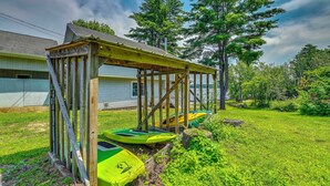 A wooden structure with a roof, possibly a porch or covered area, adjacent to a house with a visible garage door. - Lakefront Gloversville Home w/ Beach + Dock! (Gloversville)