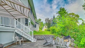 A house with a covered porch, a stone wall, and a small garden. - Lakefront Gloversville Home w/ Beach + Dock! (Gloversville)