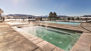 A hot tub area with a pool, surrounded by a fence, and a view of mountains in the background. - Walk to Winter Park Bus From Fraser Condo! (Fraser)