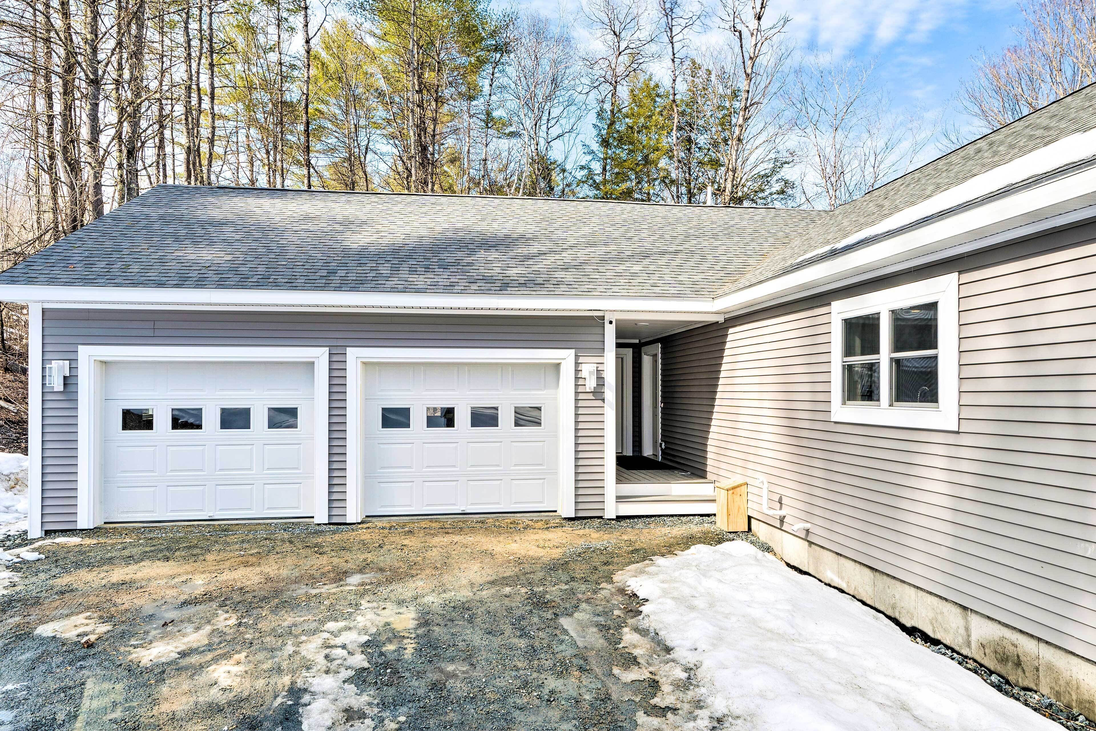 A two-car garage attached to a house with a covered entryway and a small porch.