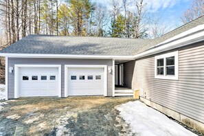A two-car garage attached to a house with a covered entryway and a small porch.