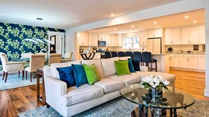 A modern living room with a sofa, coffee table, and dining area.