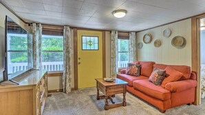 A cozy living room with a wooden desk, a red sofa, and a small table. - Near Hiking + Dining: Dtwn Sylva Cottage! (Sylva)