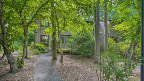 A pathway leading to a building surrounded by trees and greenery. - Stylish Durham Townhome < 5 Mi to Downtown! (Durham)