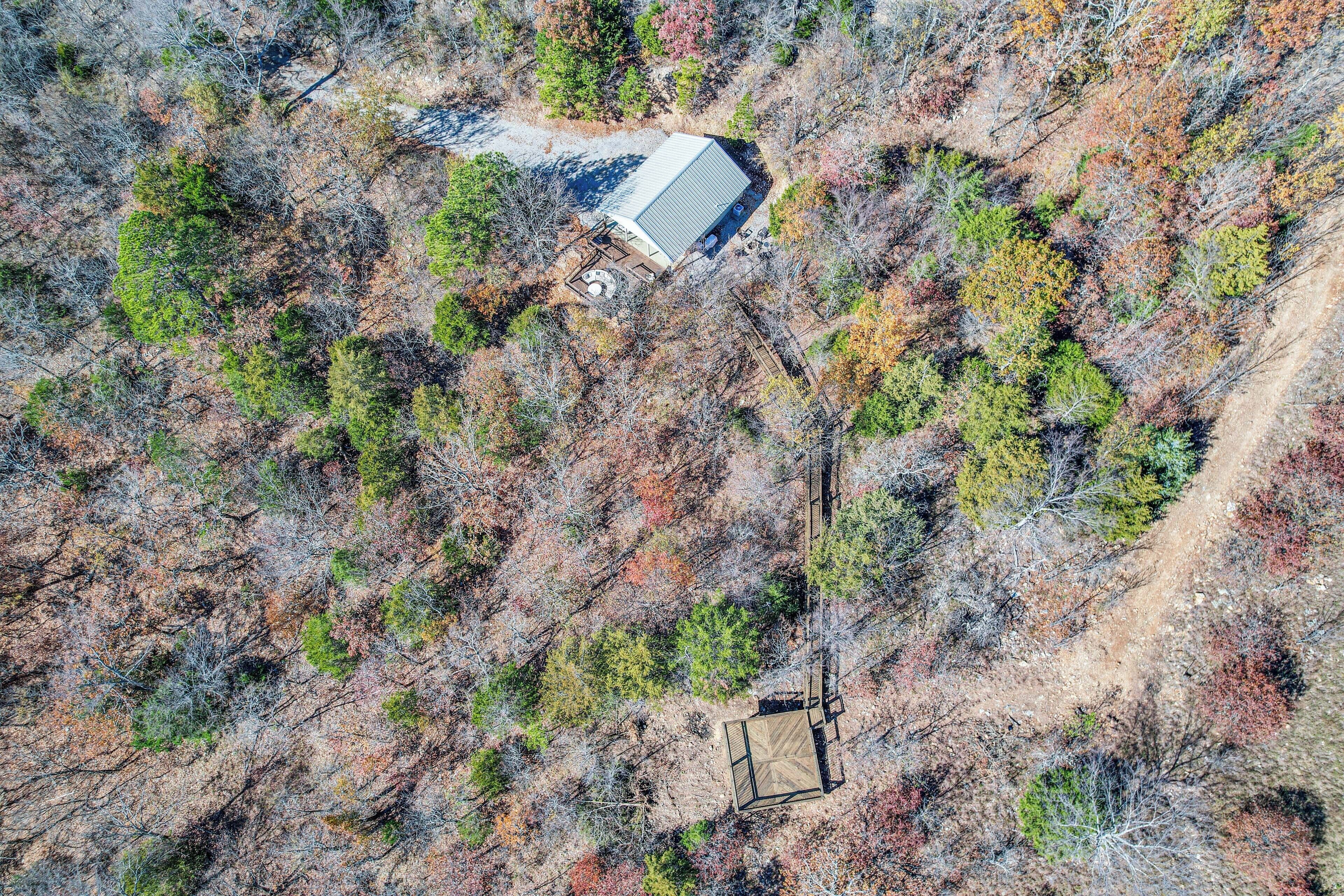 Vista aérea de una propiedad con un edificio solitario rodeado de bosque denso.