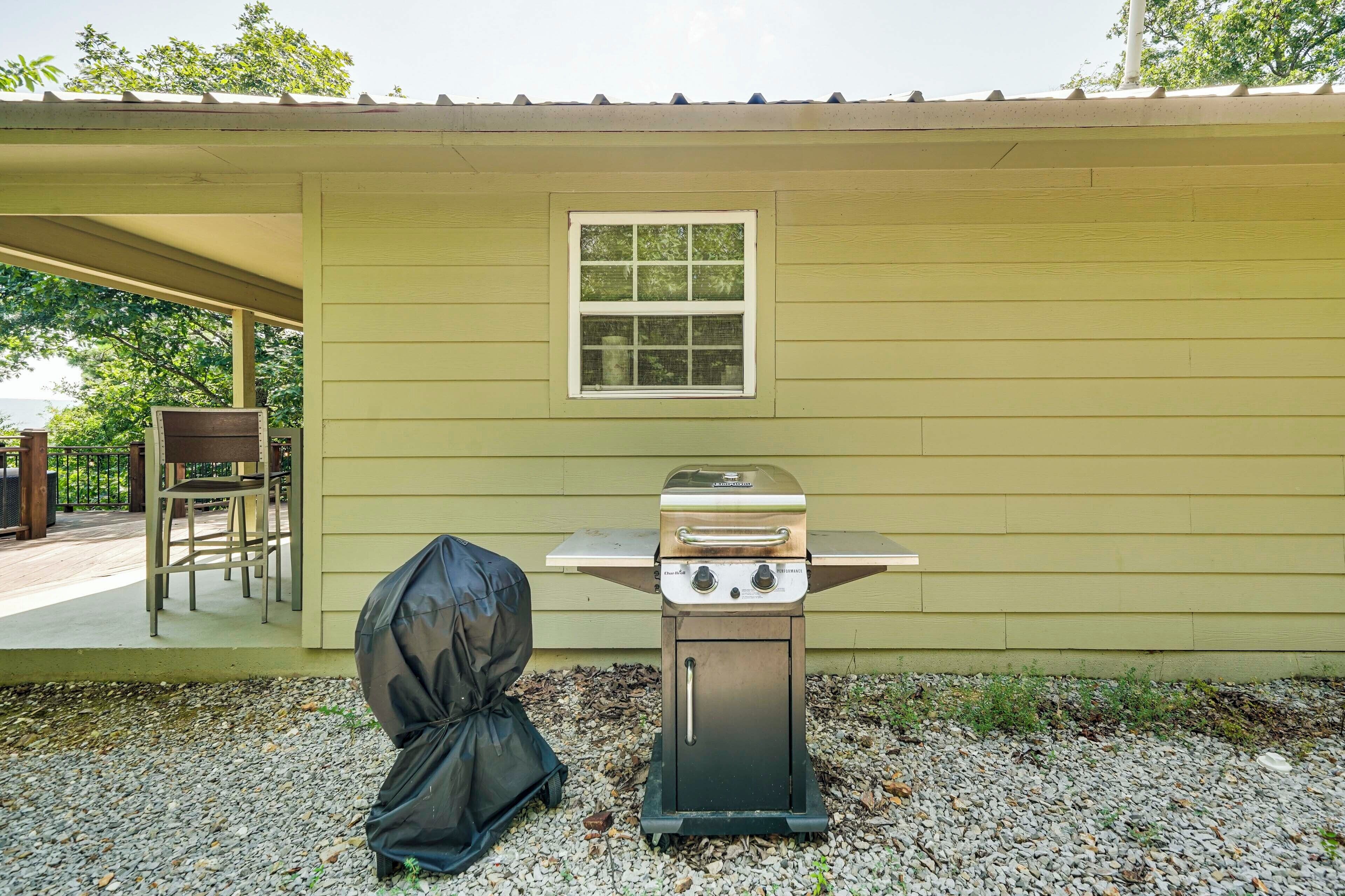 Een barbecue met afdekking, een raam en een patio stoel voor een gebouw.