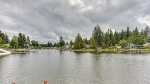 A lake with a dock, surrounded by houses and dense trees. - Spacious Apartment on Lake Sawyer w/ Fireplace! (Black Diamond)
