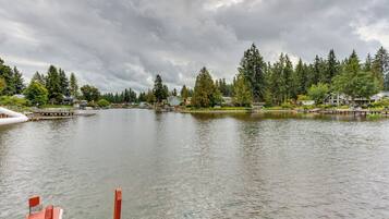 A lake with a dock, surrounded by houses and dense trees.