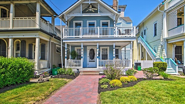 Une maison à deux étages avec un porche à l’avant, un balcon et un escalier menant au deuxième étage.