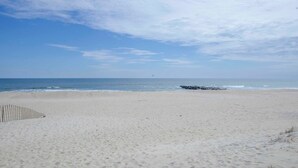 Une plage avec un ciel dégagé et une mer calme.