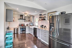 A modern kitchen with stainless steel appliances, a built-in oven, and a dishwasher.