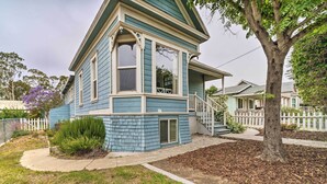 A two-story house with a prominent bay window, a front porch, and a small staircase leading to the entrance. - Charming Santa Paula Home - Walk to Downtown! (Santa Paula)