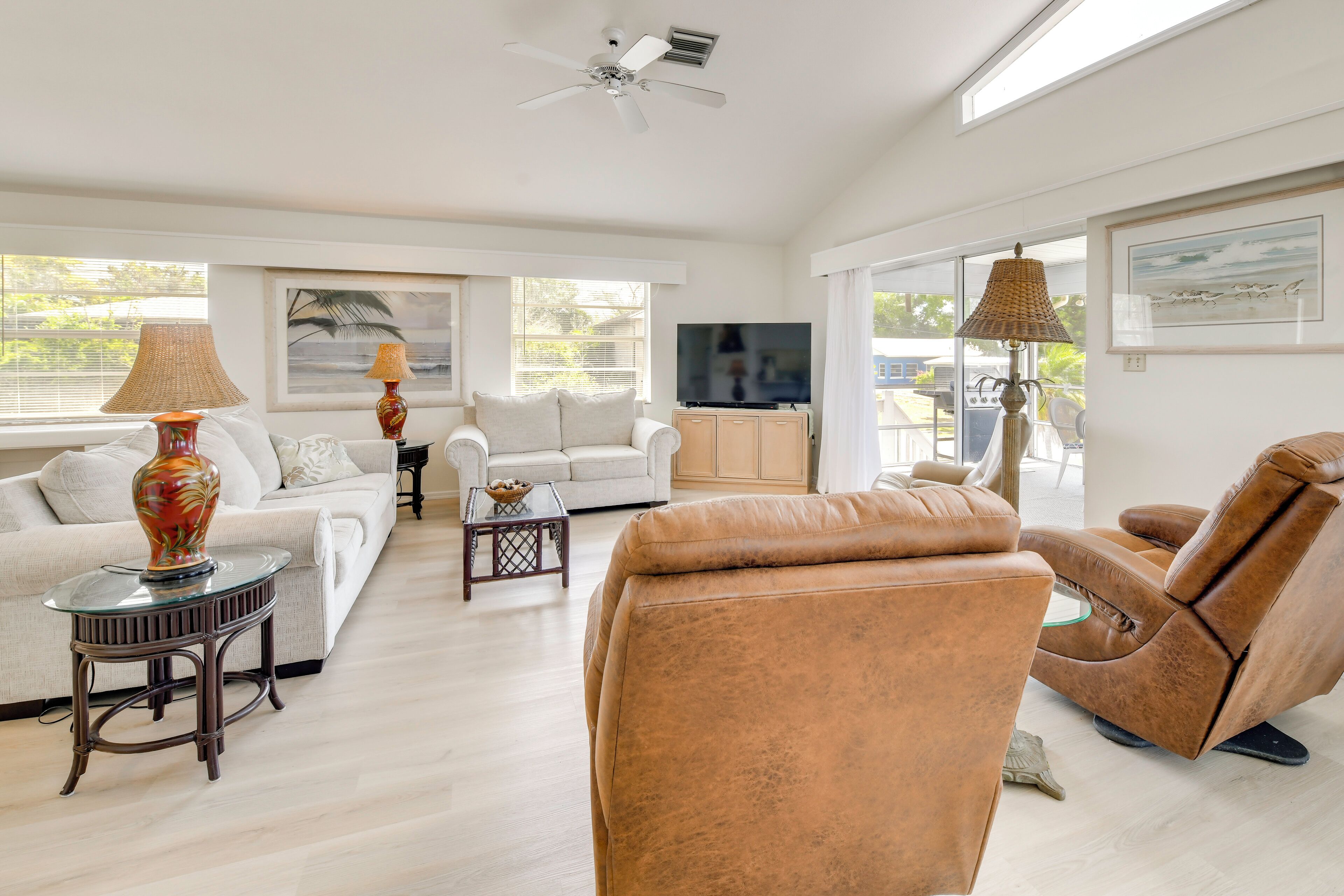 Una sala de estar moderna con sofá, sillón, televisor y objetos decorativos.