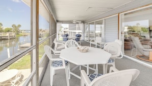 A covered outdoor patio with a white table and chairs, a ceiling fan, and a view of a marina. - Canalfront Home w/ Private Dock - 5 Mi to Beaches! (Englewood)
