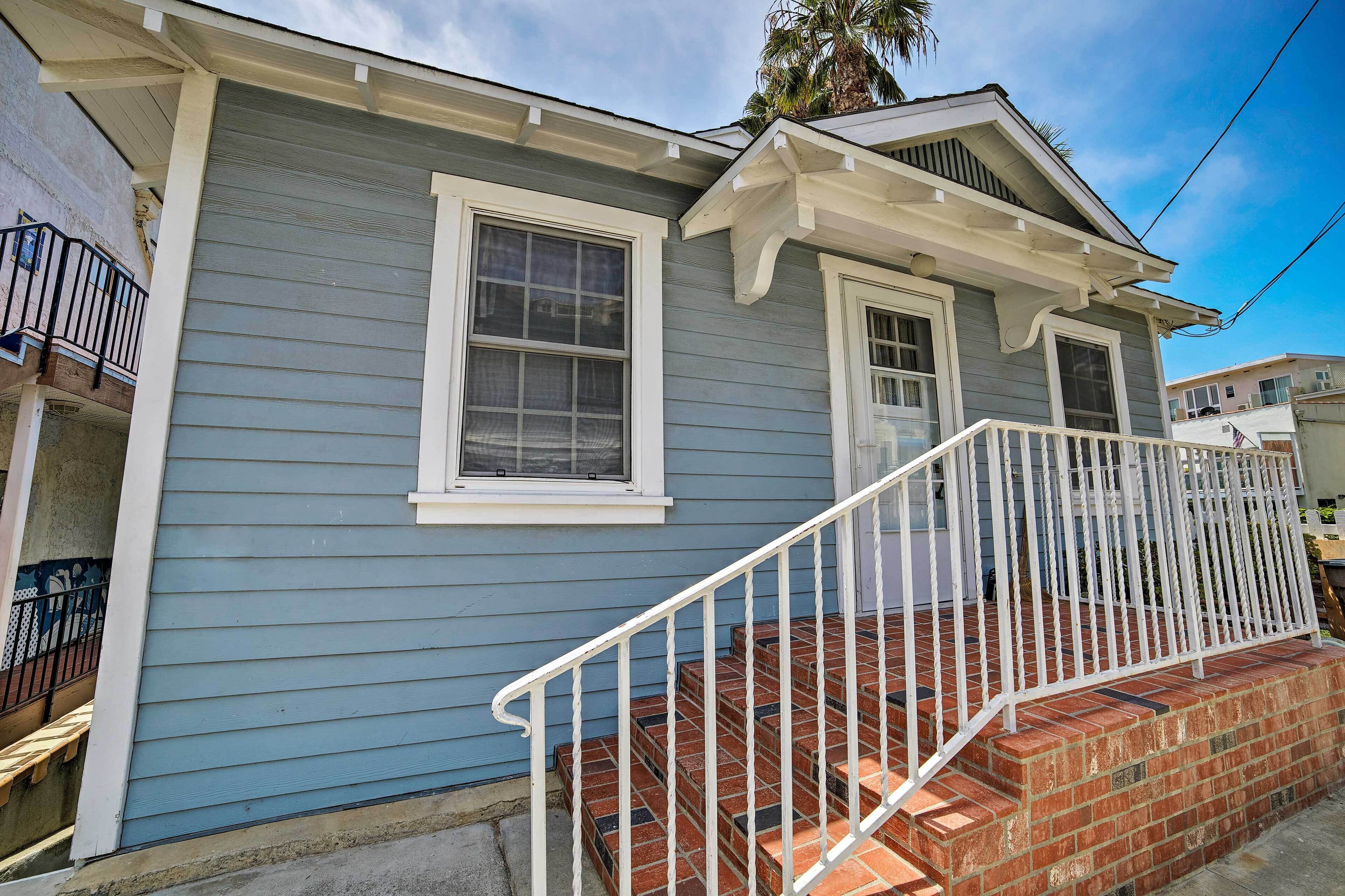 A two-story house with a front porch and a brick staircase.