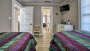 A bedroom with two beds, a TV mounted on the wall, and a dresser. - Ocean-view Home - Walk to Avalon City Center! (Avalon)