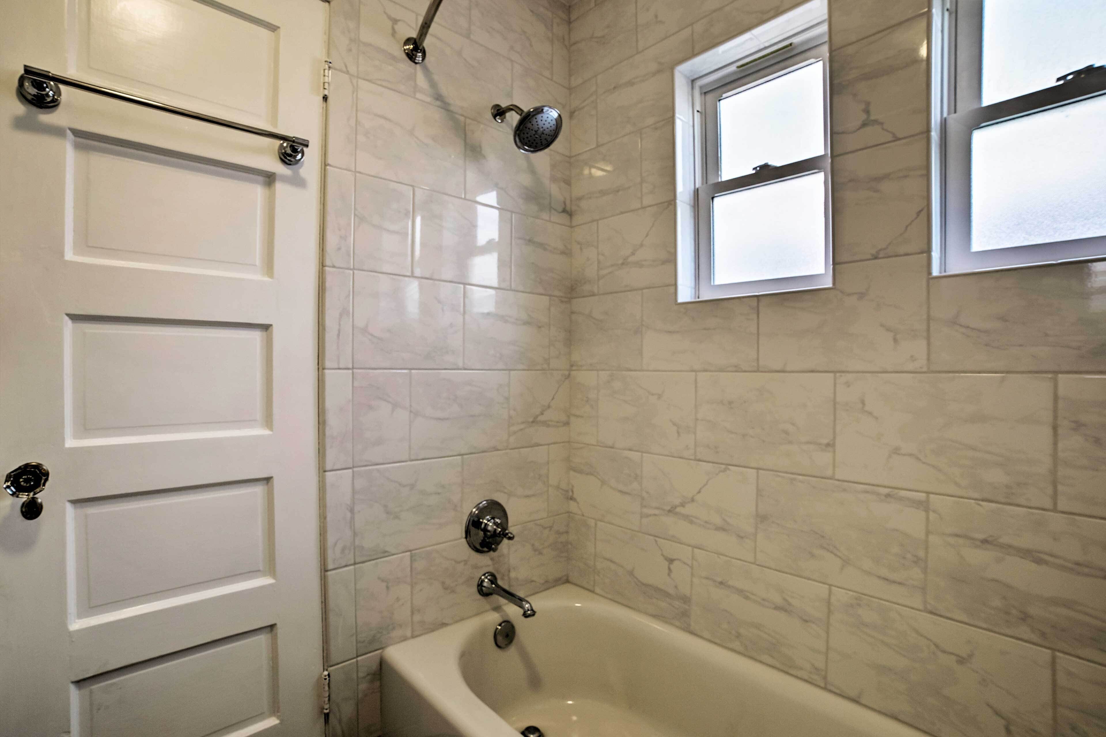 Une salle de bain avec une baignoire, une douche et une fenêtre.