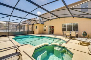 A swimming pool with a glass ceiling, lounge chairs, and a door leading to a room. - Lanai & Game Room: Vacation Home in Davenport! (Davenport)
