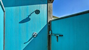 A turquoise door with a metal handle and a peephole.