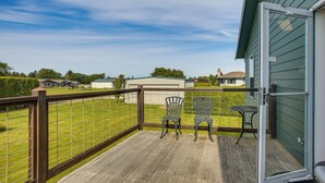 A wooden deck with a metal railing, two chairs, and a table. - Charming Sequim House w/ Olympic Peninsula Views! (Sequim)