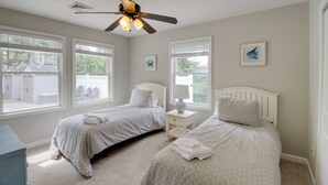 A bedroom with two beds, a ceiling fan, and large windows. - Charming Somers Point House w/ Private Pool! (Somers Point)