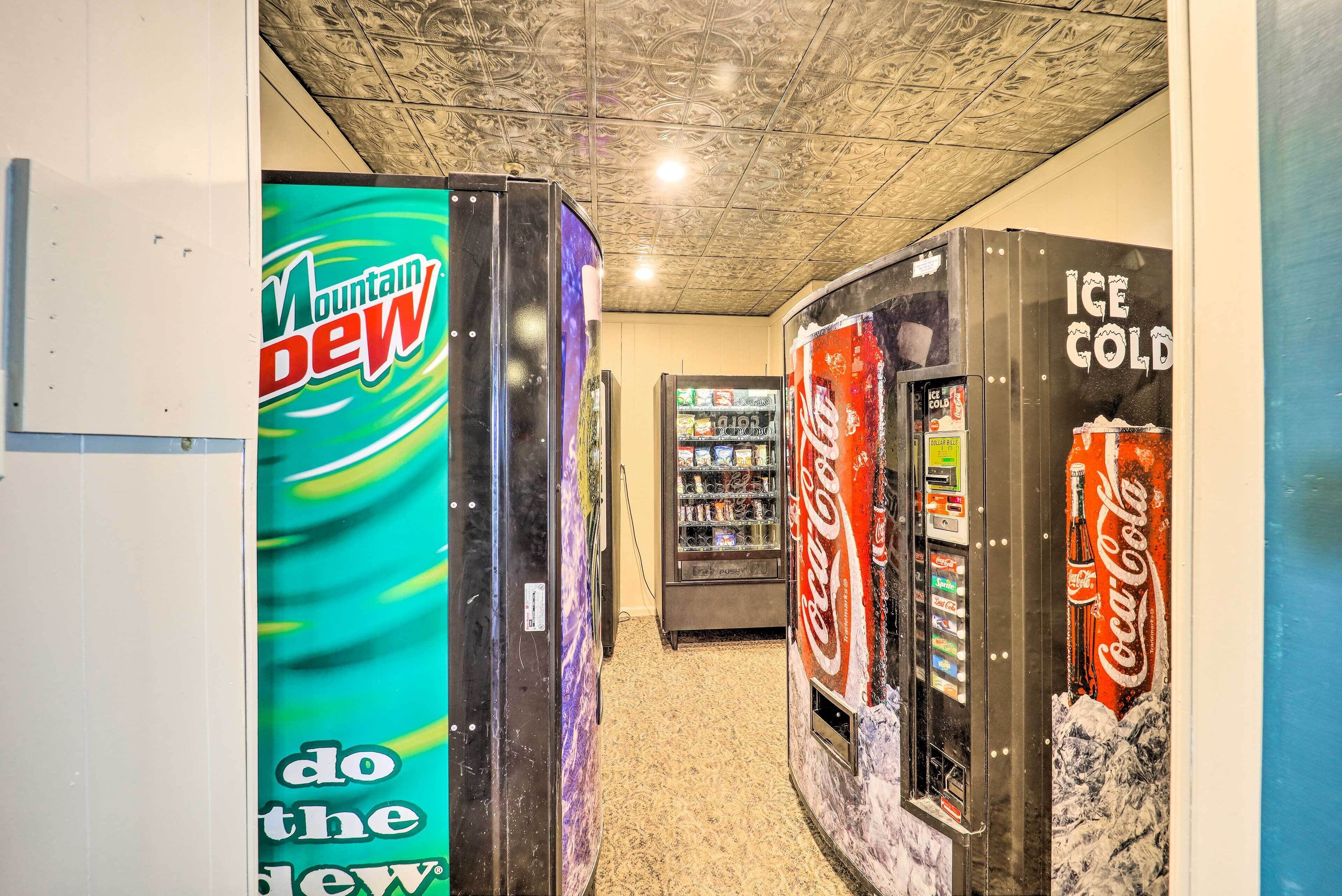 A hallway with vending machines, including Mountain Dew and Coca-Cola, and a Coca-Cola refrigerator.