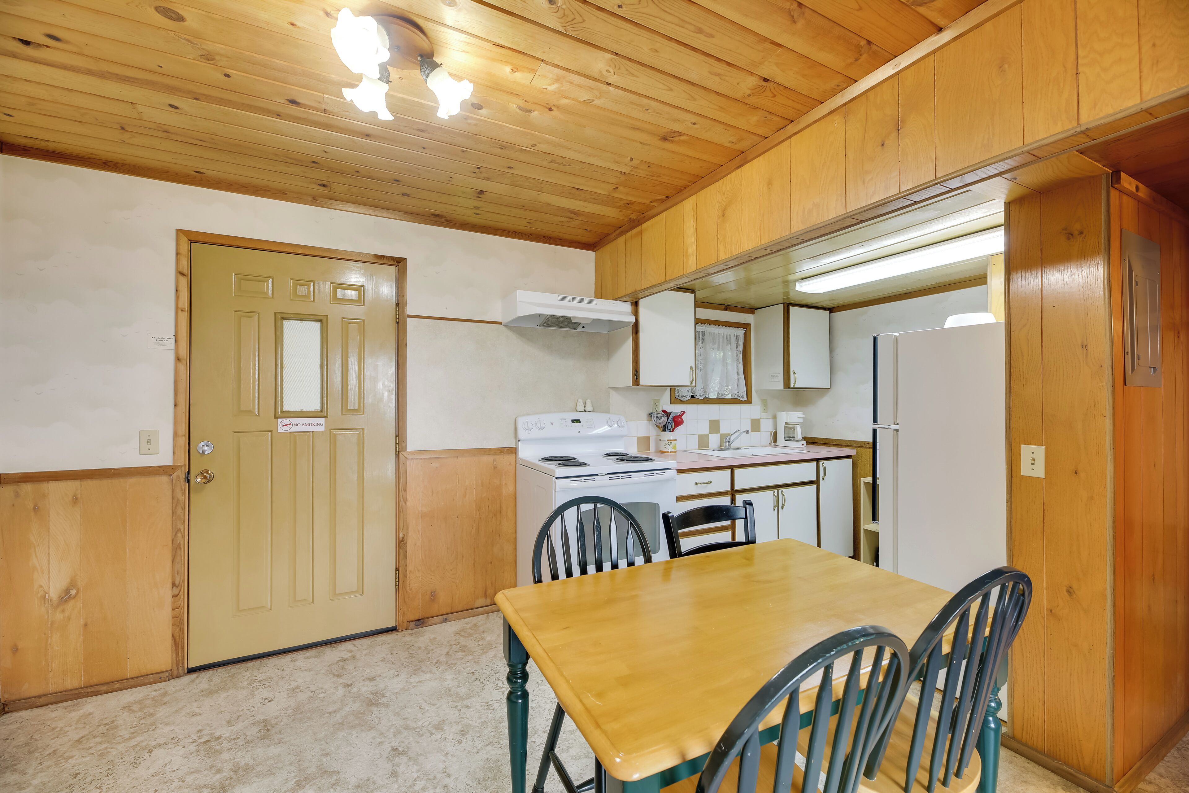 A compact kitchen with wooden cabinets, a stove, and a refrigerator.