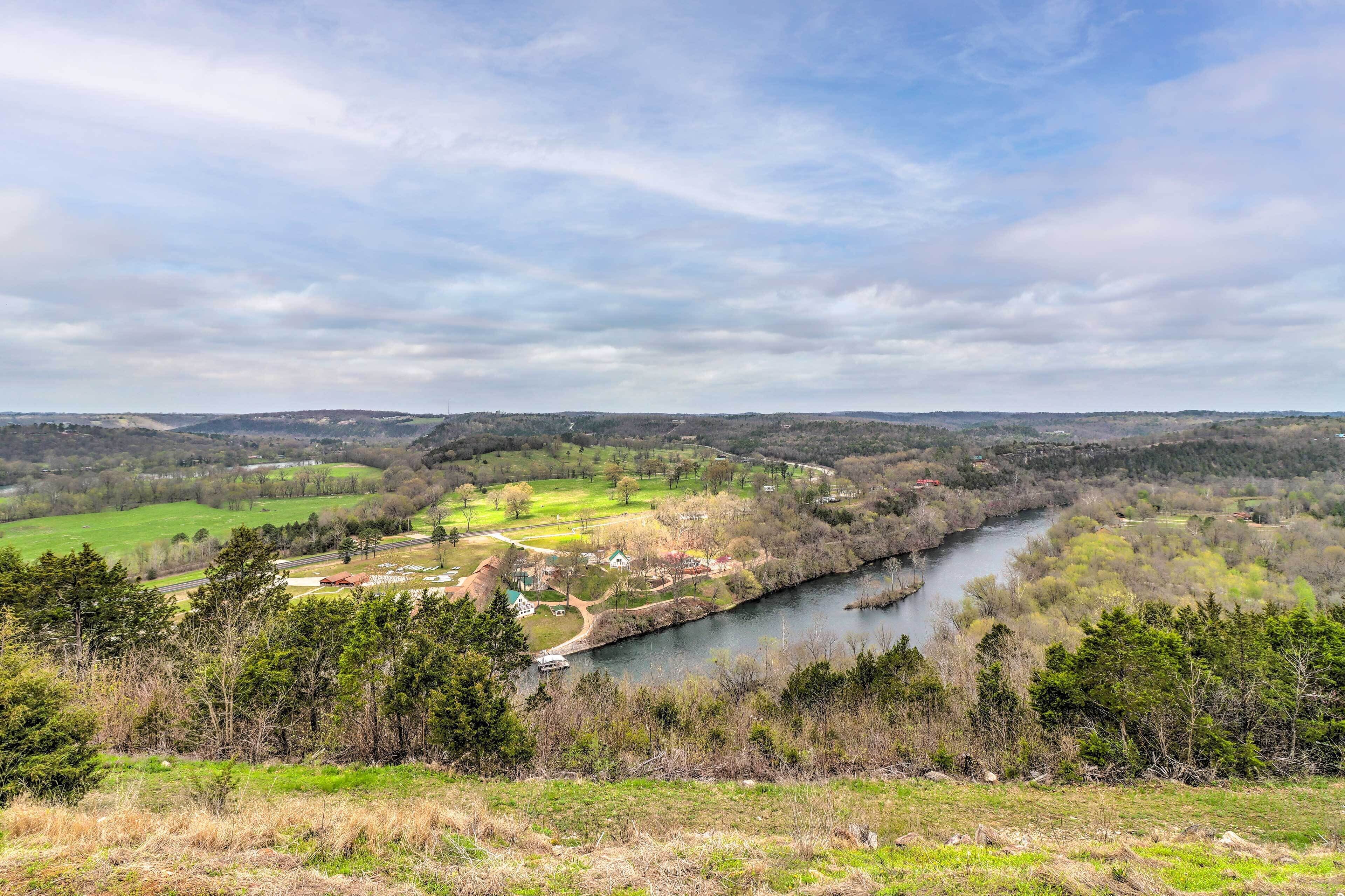 Une rivière qui traverse une vallée, avec une petite ville et des champs verdoyants.