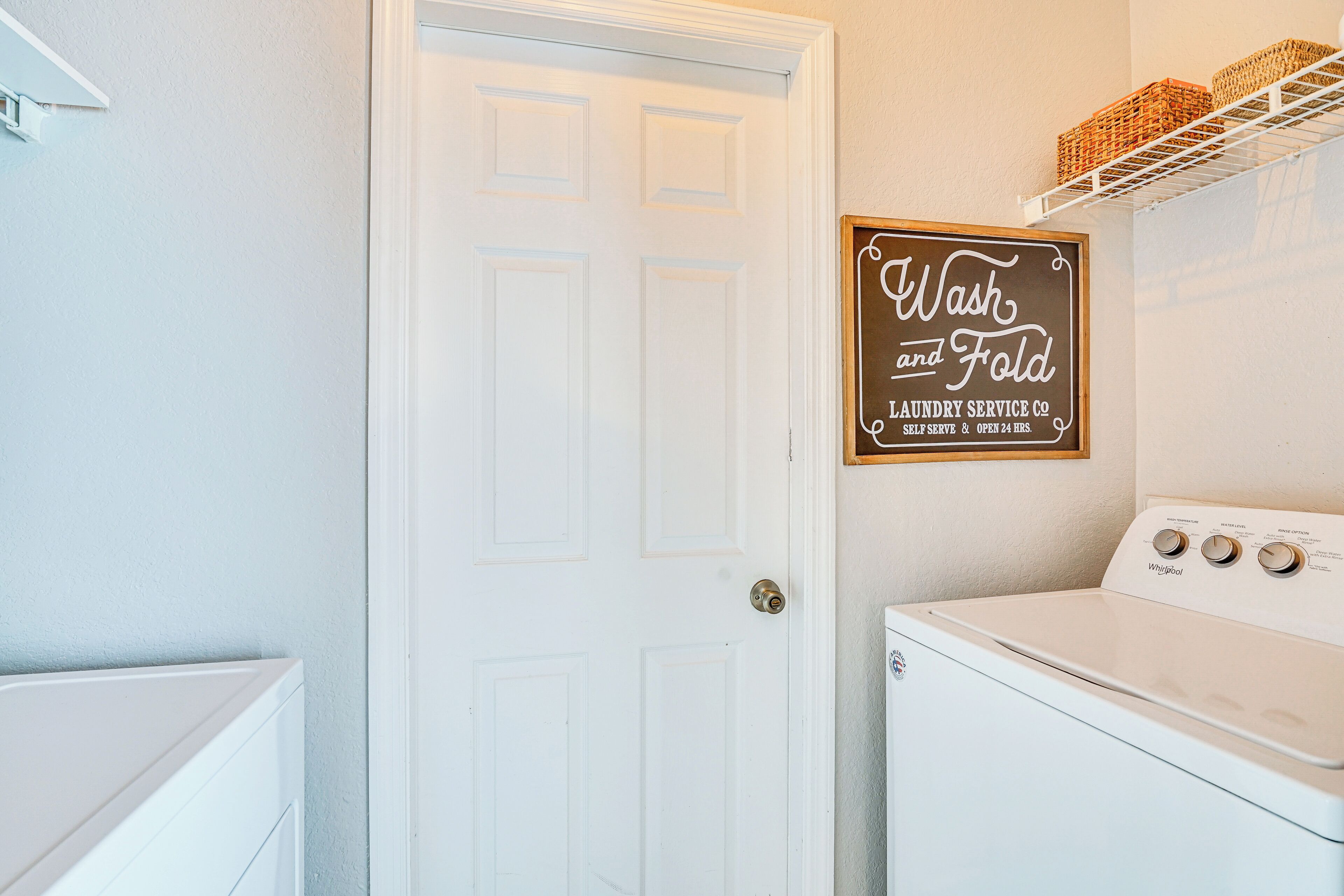 A laundry room with a sign that reads "Wash and Fold Laundry Service Co."