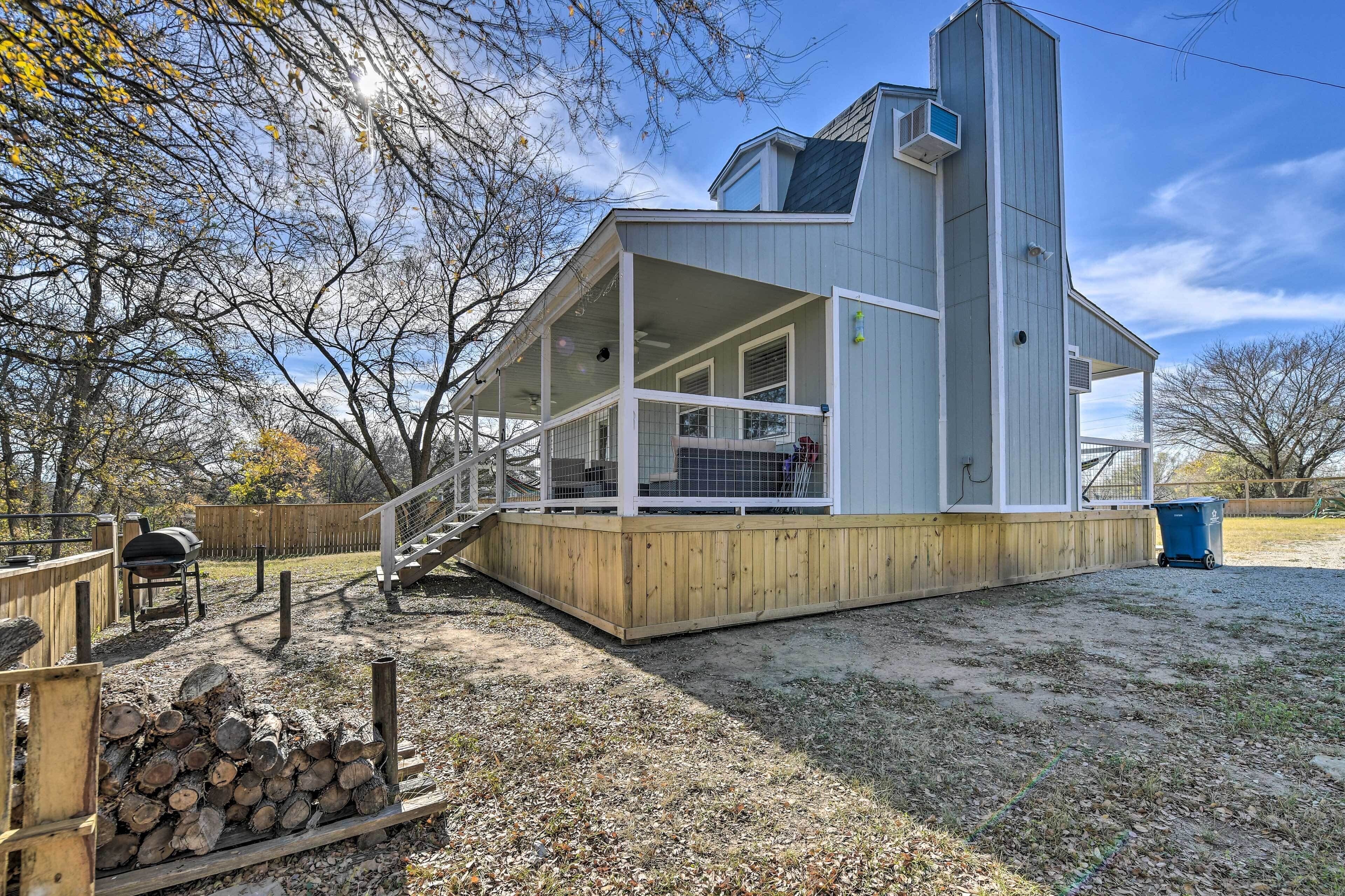 A single-story house with a covered porch, a chimney, and a wooden deck.