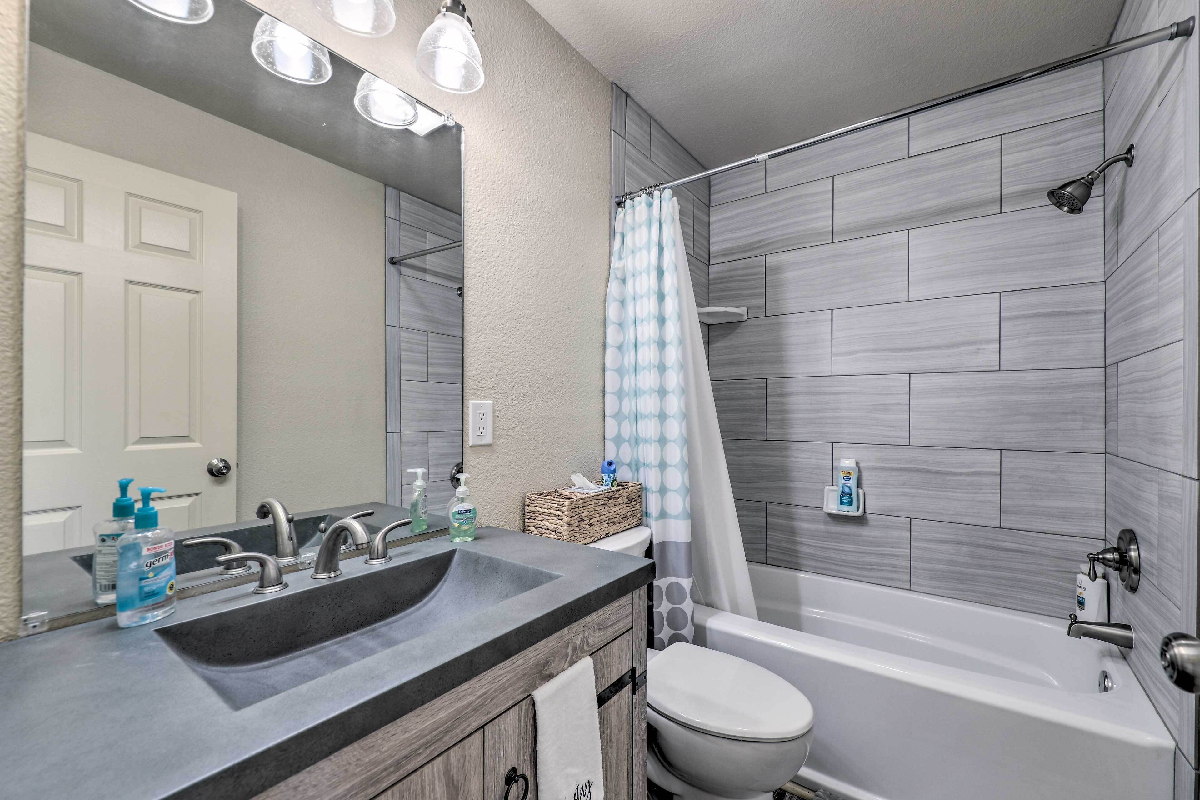 Une salle de bain équipée d’un lavabo, d’un miroir, de toilettes et d’une douche.