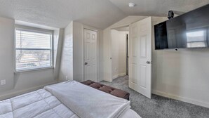 A bedroom with a bed, a window, and a door leading to another room. - Bright Brownwood Home With On-site River Access! (Bangs)