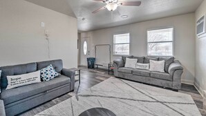 A living room with two grey sofas, a ceiling fan, and a patterned rug. - Bright Brownwood Home With On-site River Access! (Bangs)