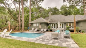 A house with a swimming pool, outdoor seating, and a well-maintained lawn. - Golf, Dine & Swim: Sleek Palmetto Dunes Home! (Hilton Head Island)