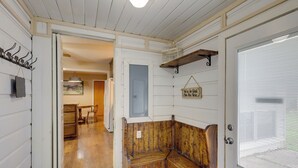 Un banco de madera en un pasillo con una puerta que da a otra habitación.