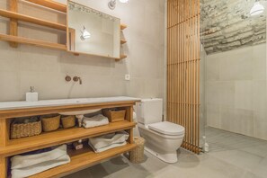 A modern bathroom with a wooden vanity, a toilet, and a shower area. - Casa Stella in Varenna (Varenna)
