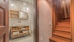 Ein Badezimmer mit einem Holzlager, einem Spiegel und einem Handtuchhalter.