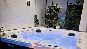 A hot tub with a wooden bench and candles. - 1 Bed Flat - Sleeps 2 - Jacuzzi - Parking - Wifi (Birmingham)