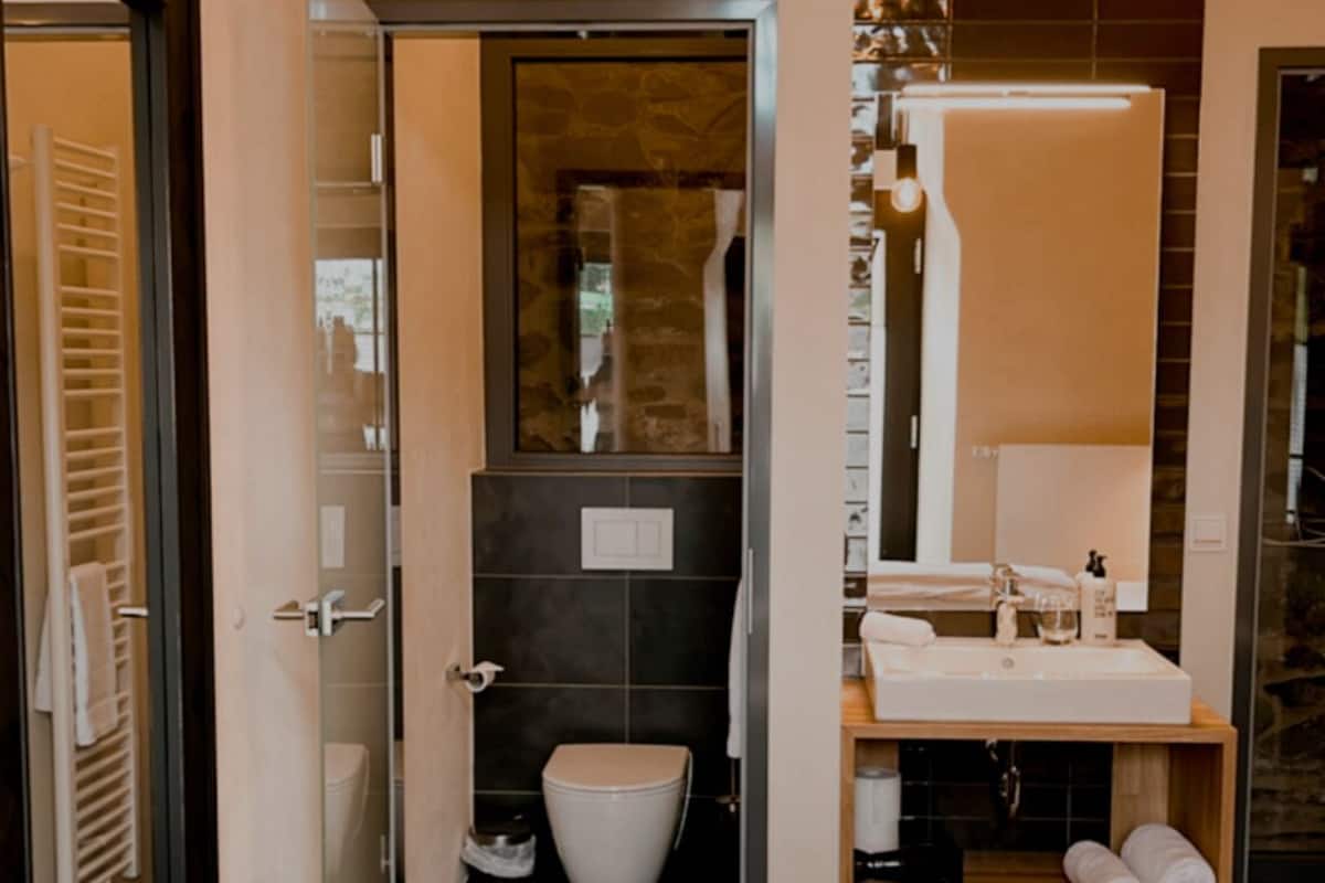 Une salle de bain moderne avec des toilettes, un lavabo et un miroir.