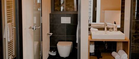 Un baño moderno con inodoro, lavabo y espejo.