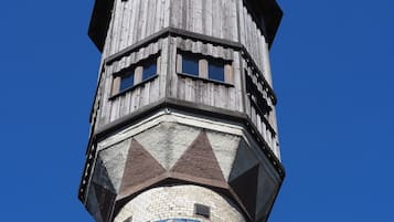 A tower with a wooden upper section and a lower section with colorful mosaic tiles.