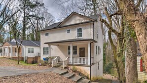 A two-story house with a front porch, a small front yard, and a driveway leading to the house. - Chic Atlanta Home < 4 Mi to Mercedes-benz Stadium! (Atlanta)