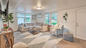 A living room with a sectional sofa, a coffee table, a striped armchair, and a wooden side table.
