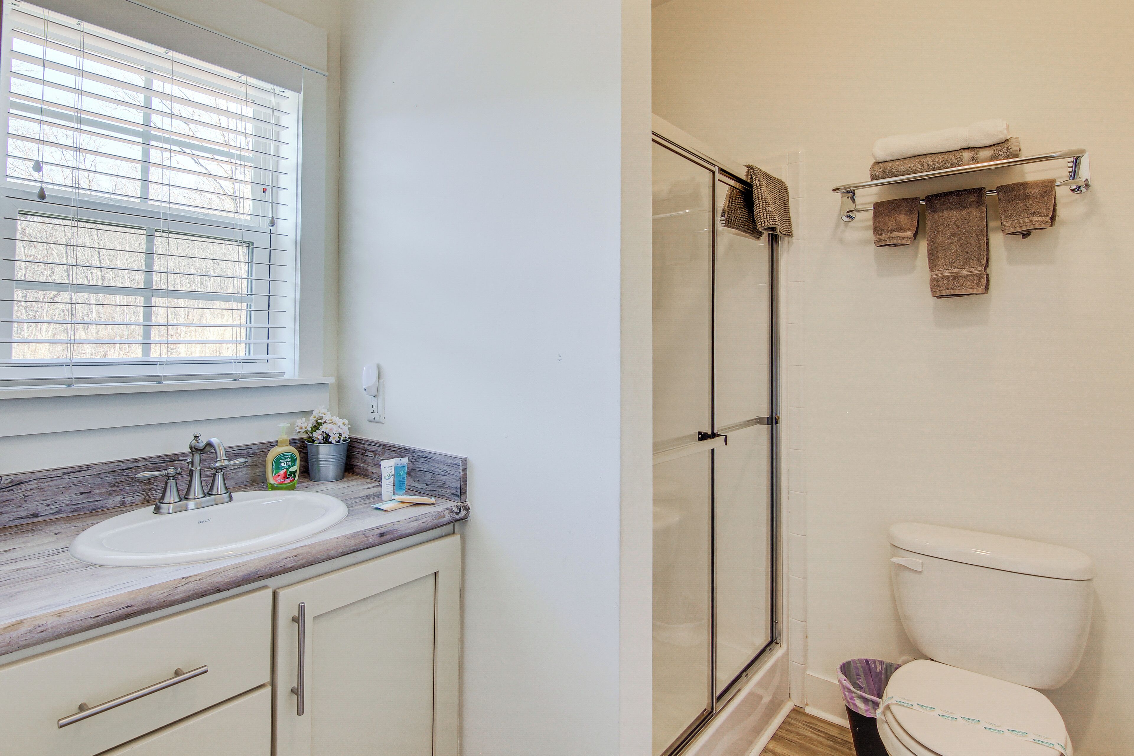 A bathroom with a sink, toilet, and shower.