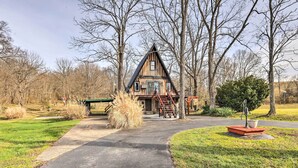 Une cabane avec un toit très pentu, un escalier menant à l’entrée et une allée pavée.